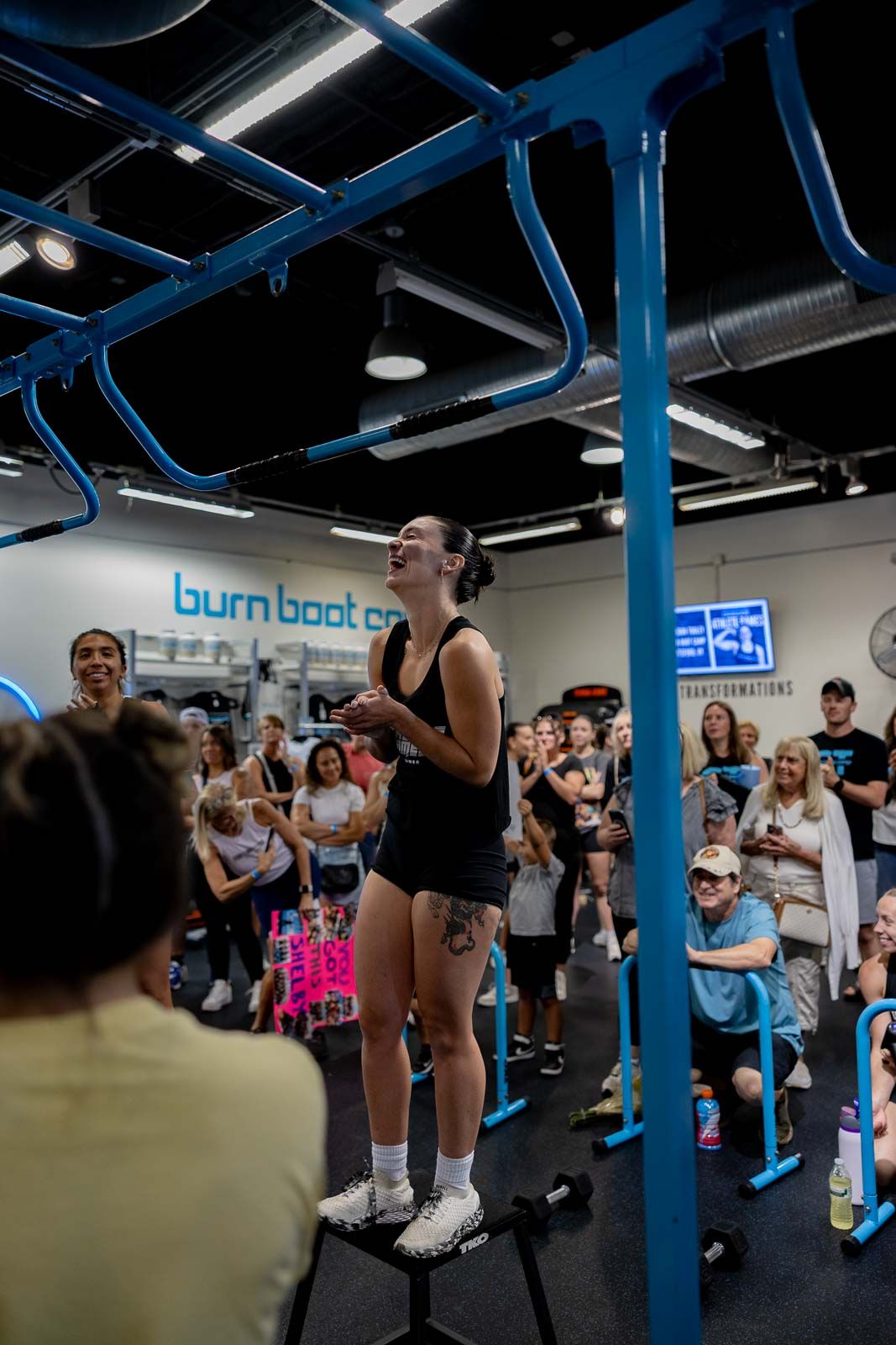 Workout session at Burn Boot Camp with participants gathered around blue structural beams.