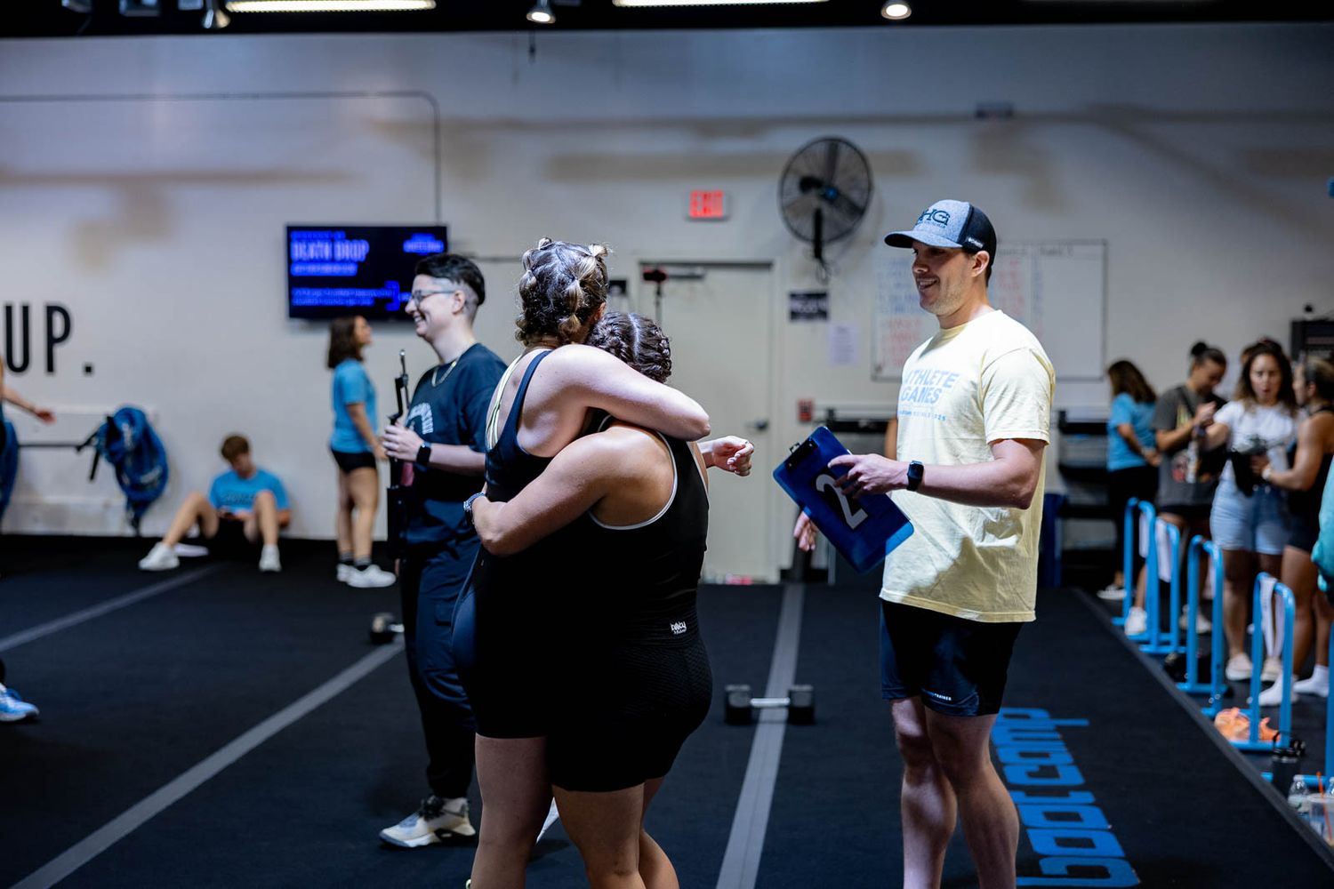 Athletes performing plank exercises during an indoor workout session at a CrossFit-style gym.