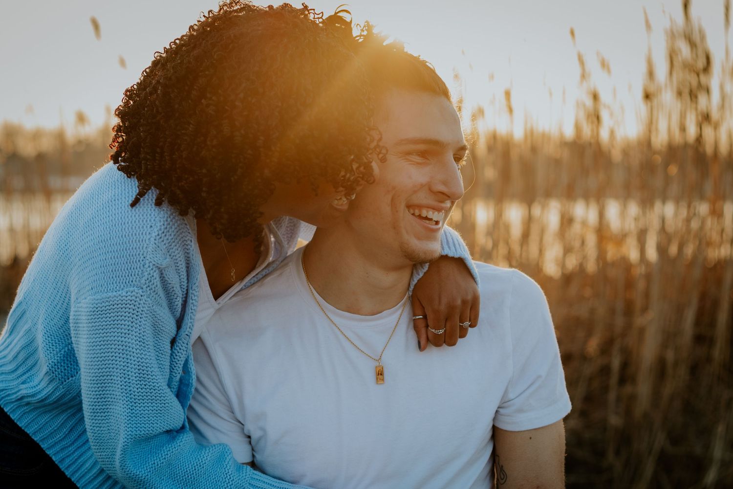Intimate moment between couple laughing together in golden hour light.