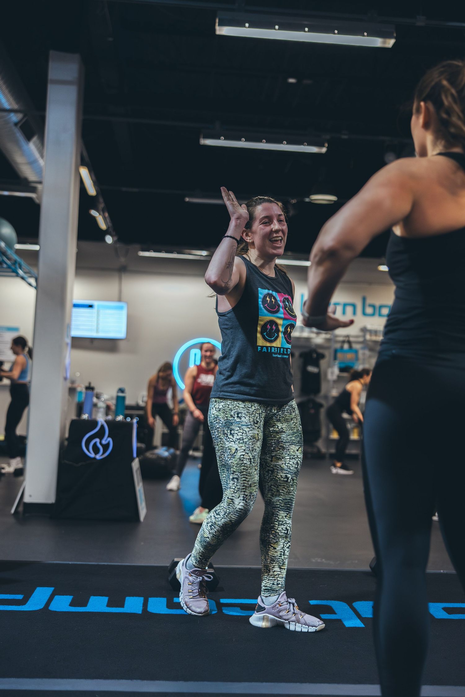 A group workout session shows participants engaged in an energetic exercise routine.
