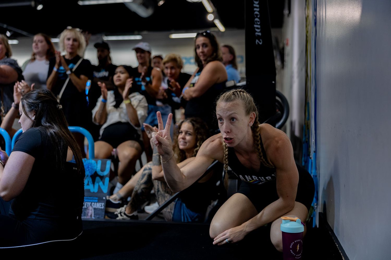 People are sitting in rows of chairs watching a fitness training class or presentation.