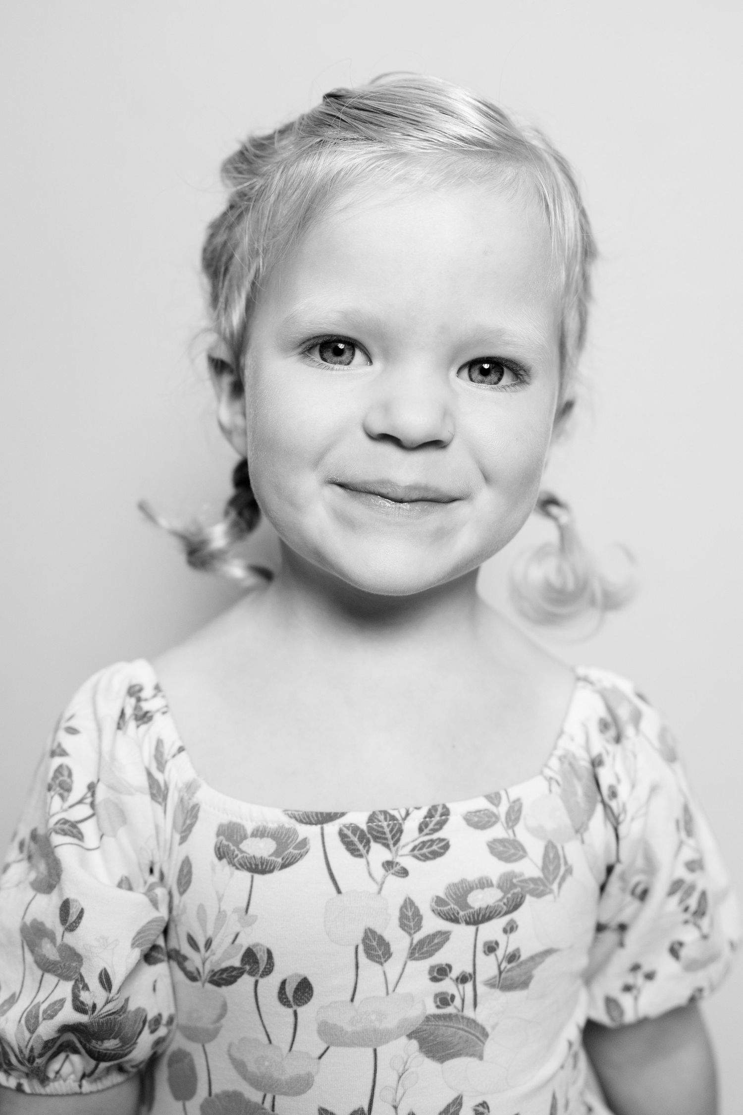 Black and white portrait series showing close-up expressions in floral print clothing.