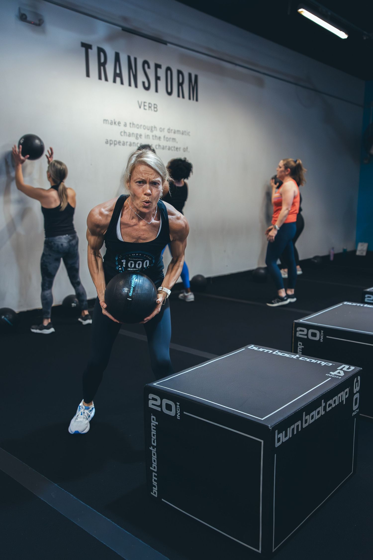 Athlete performing exercise with weighted box at Transform fitness area.