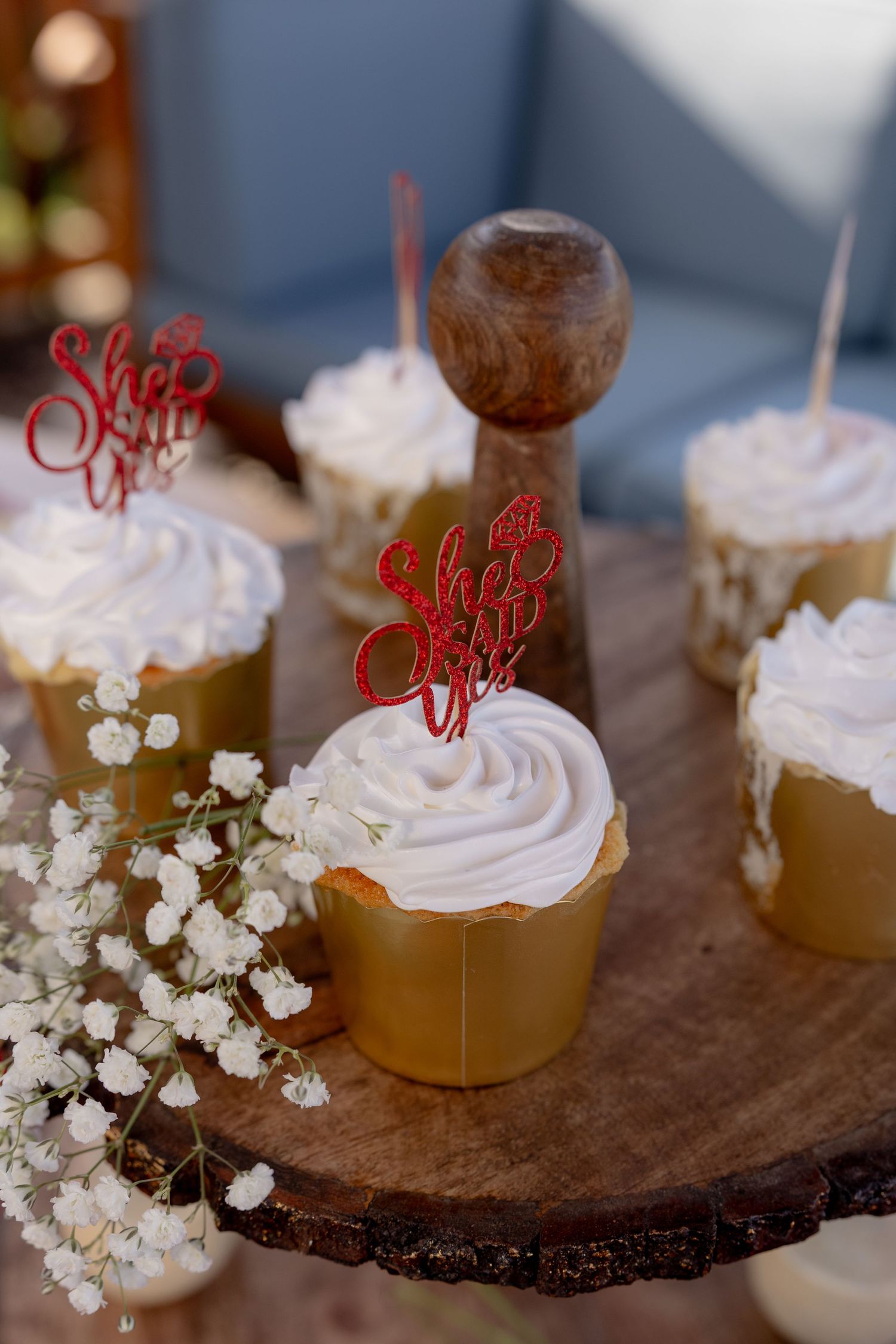 Elegant dessert display featuring whipped cream topped treats with red decorative toppers and baby's breath flowers.