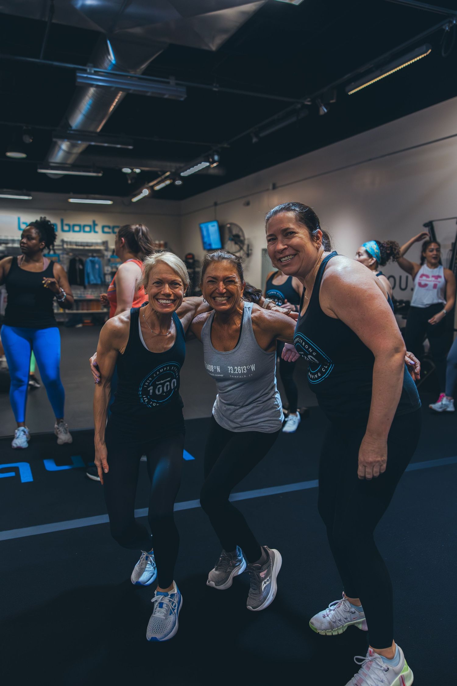 Small group sharing a laugh during workout session in modern fitness facility.