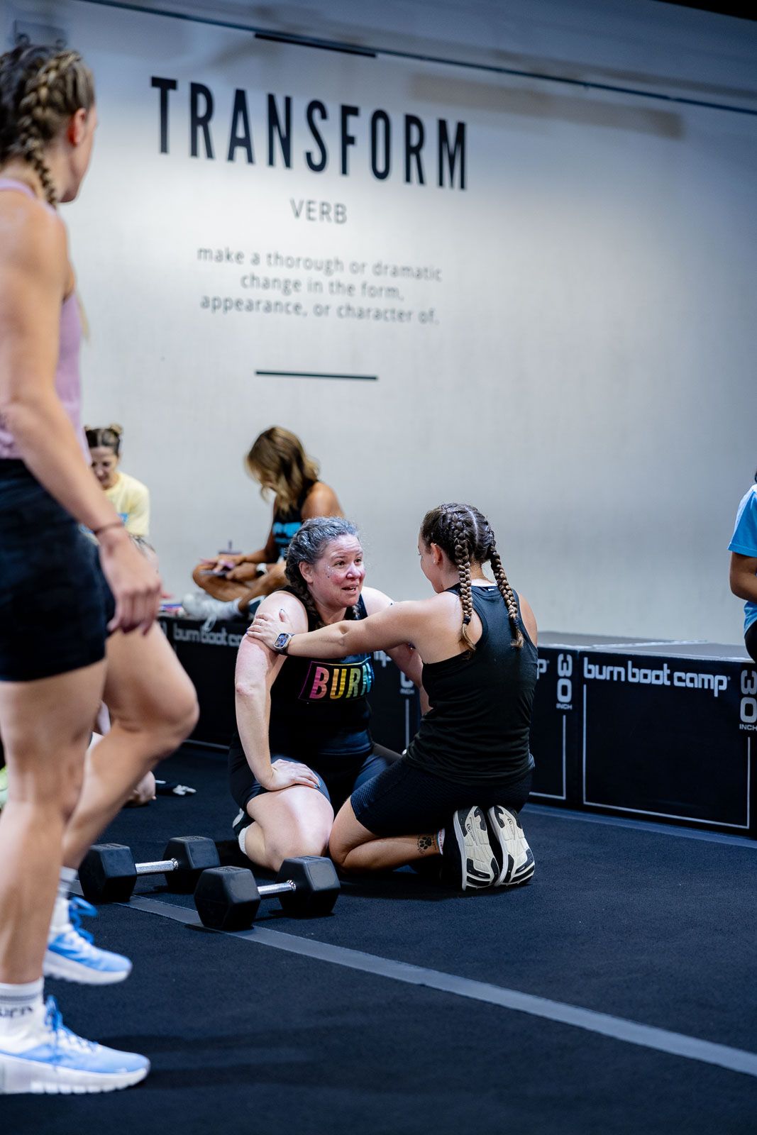 Athletes training in a gym with Transform text visible on the wall during an indoor workout session.