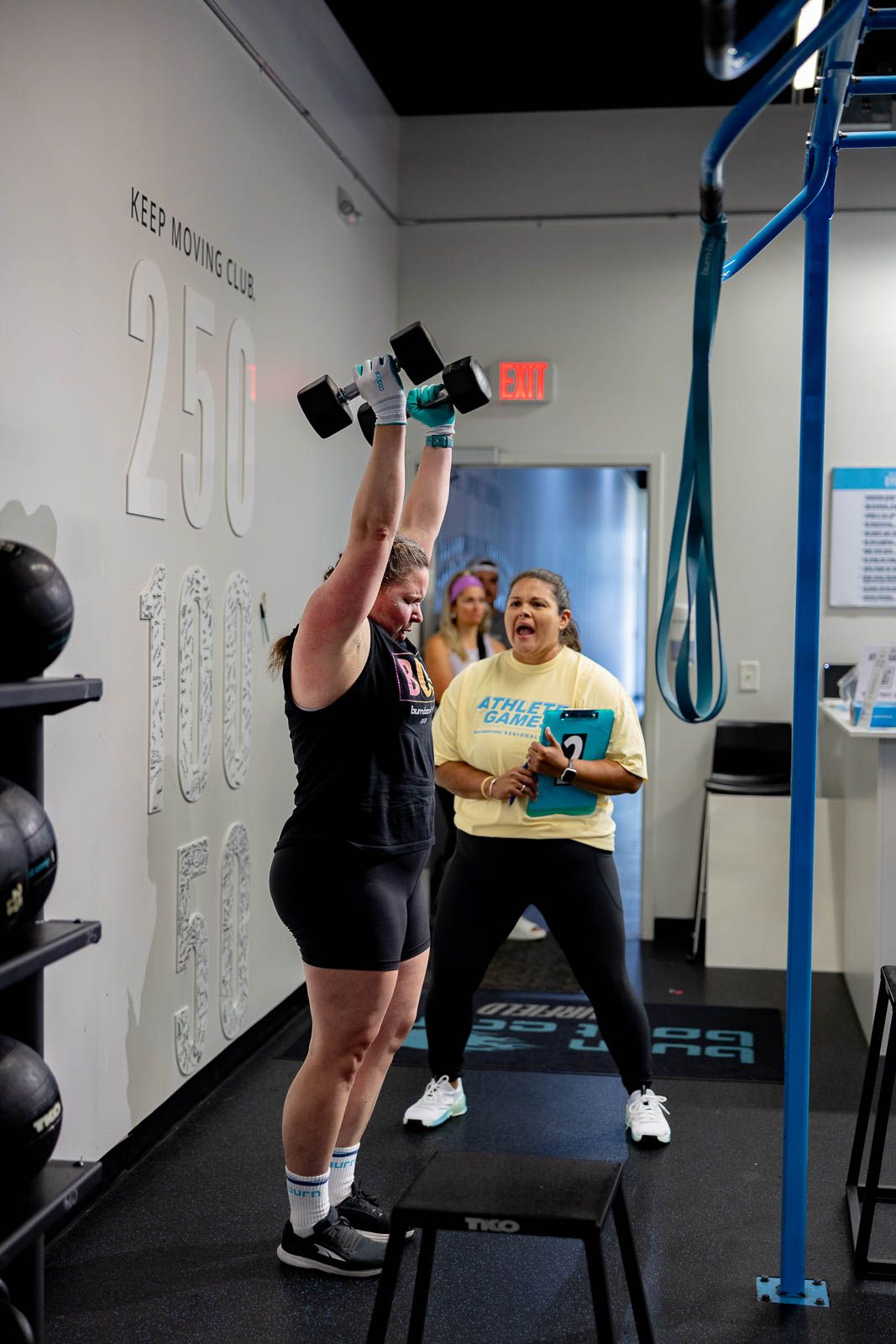 Group exercise class members performing workouts with resistance bands in a modern fitness facility.