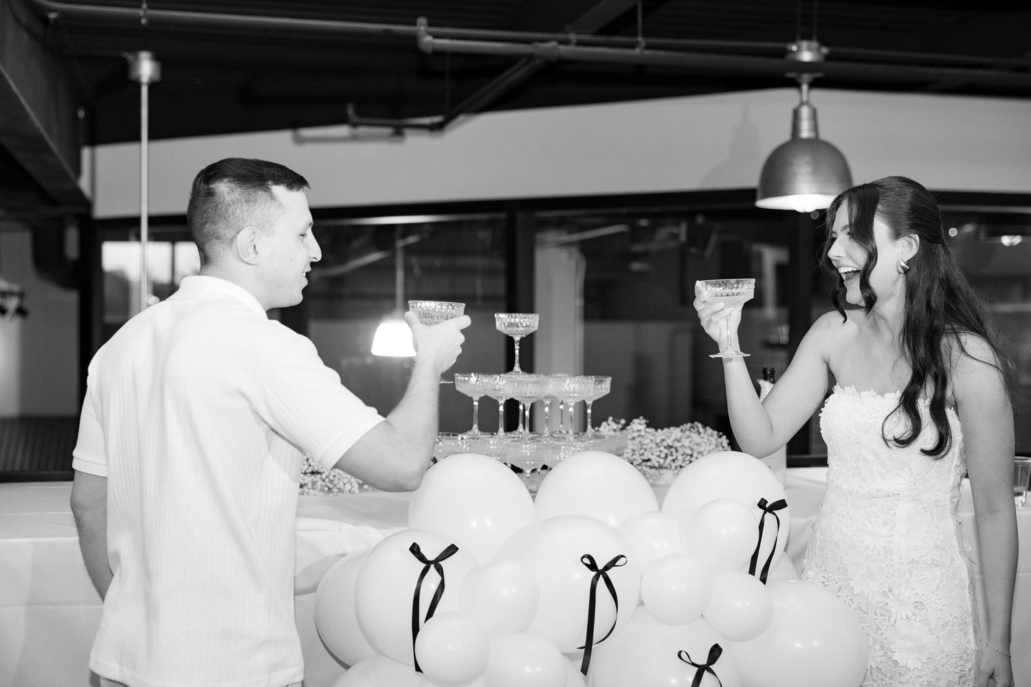 Black and white panoramic shot of wedding guests gathered at reception tables.