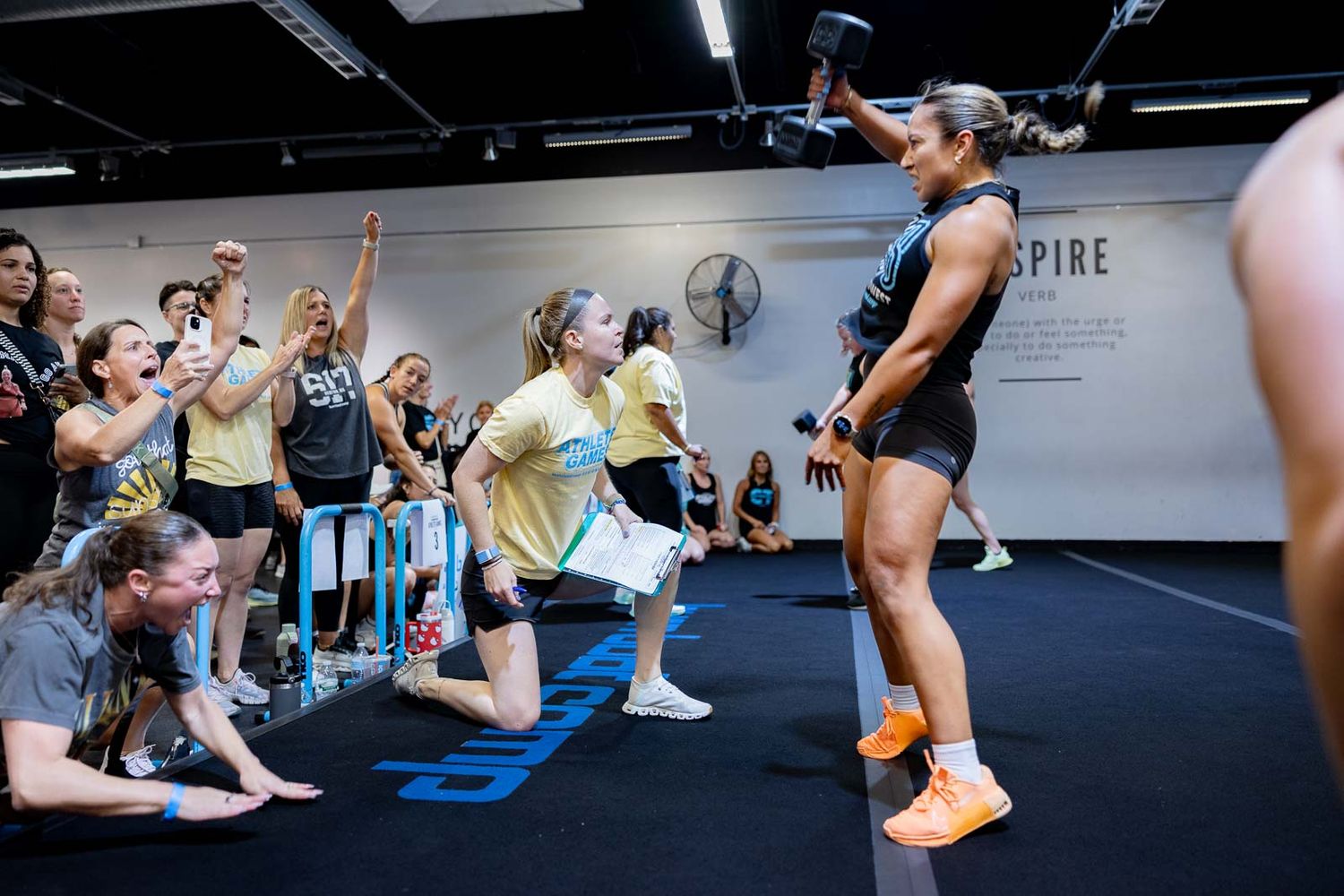 People stretching and warming up on blue exercise mats during a group fitness class.