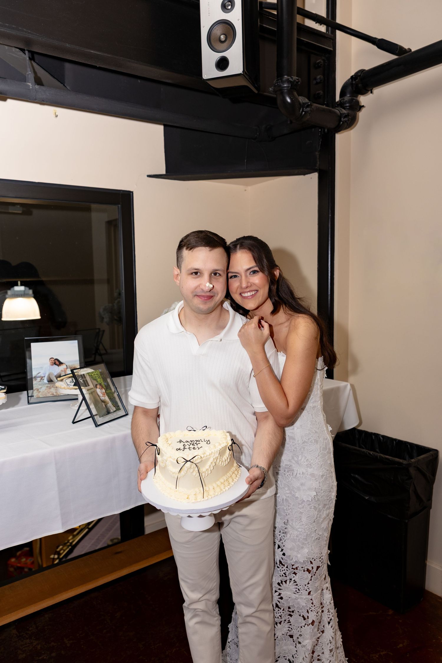 Couple cuts their wedding cake together during reception celebration.