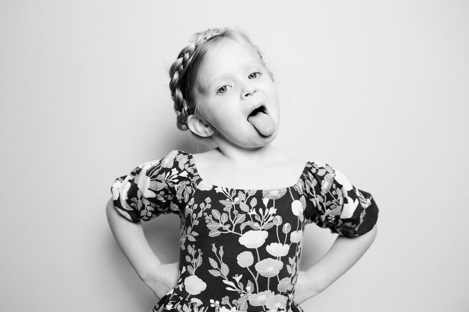 Black and white photo series showing expressive poses and emotions in a floral patterned dress.