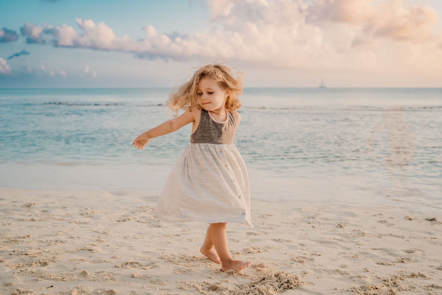 Children playing freely on white sand beach with turquoise waters in the background.