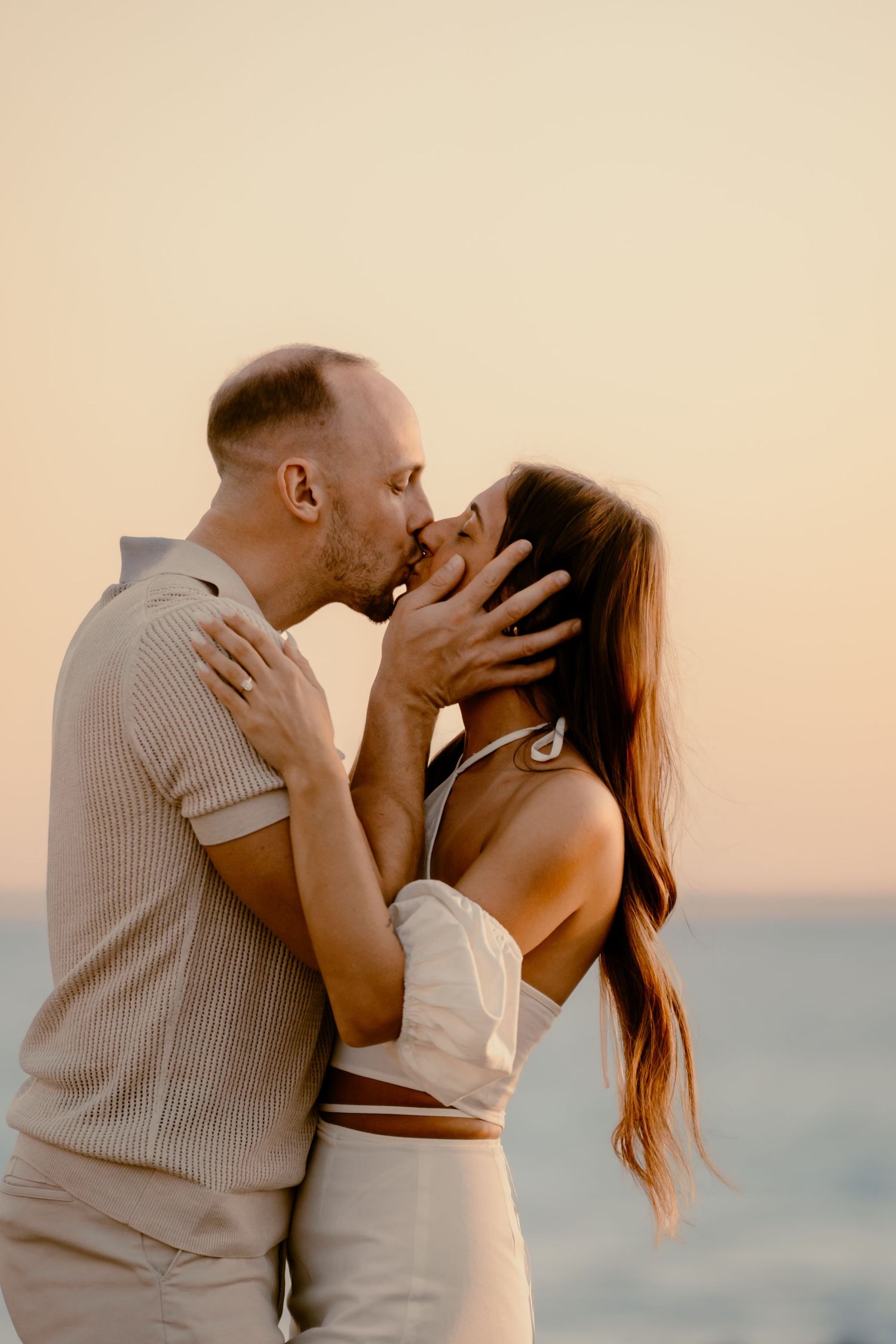 An intimate moment between a couple during their sunset beach photoshoot.