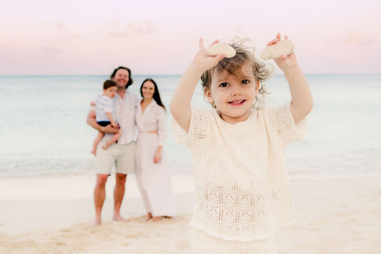 Happy family enjoying quality time together on an idyllic beach at sunset.