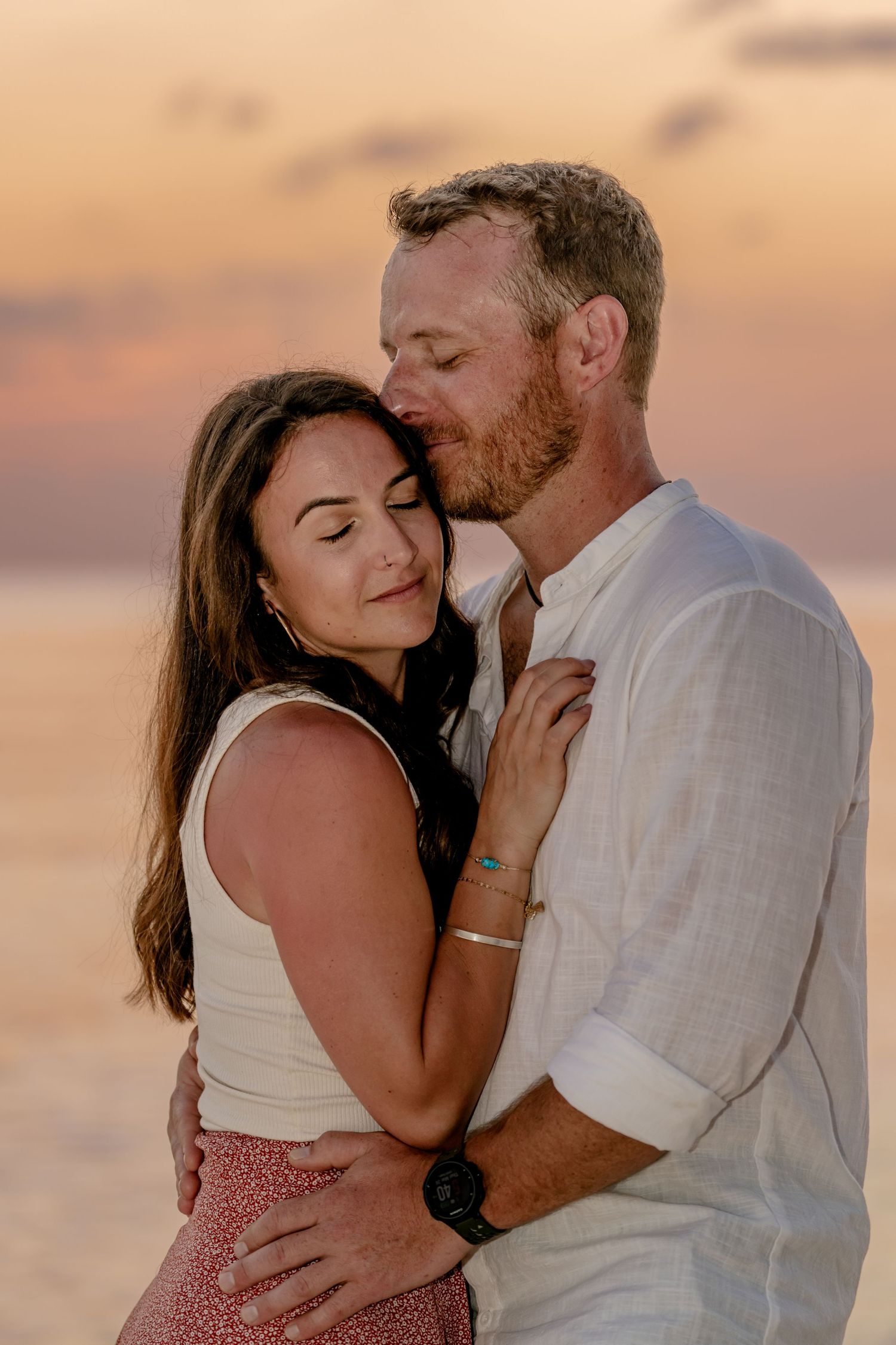 Intimate beach photoshoot during golden hour sunset.