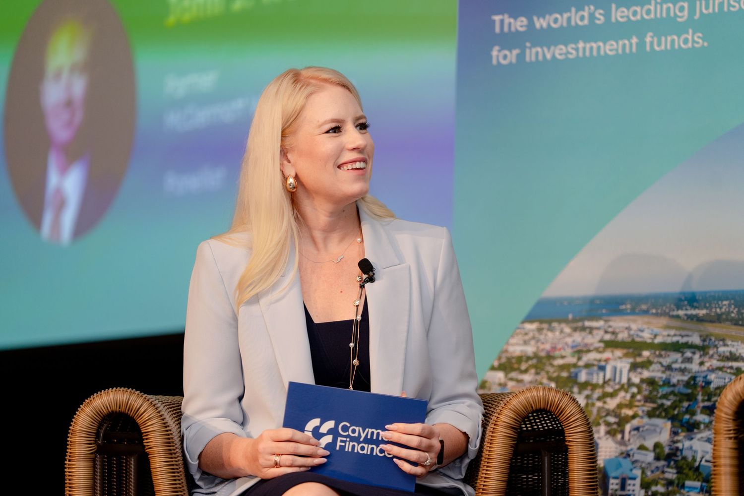 Professional speaker presents at finance conference with coastal backdrop display.