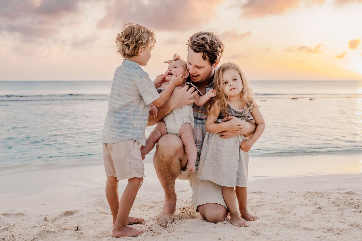 Candid beach photoshoot with people walking and playing in the sand during golden hour.