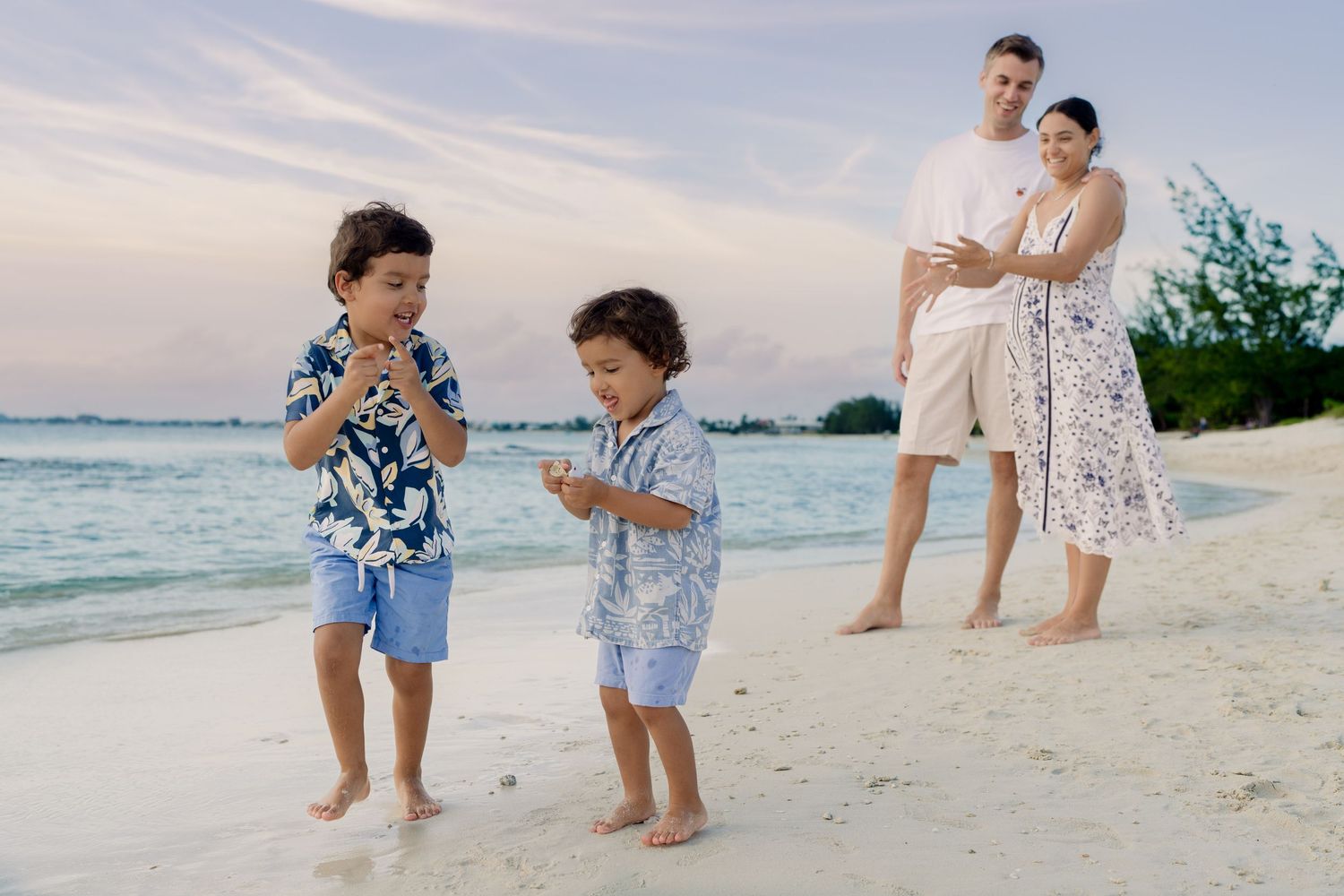 Children playing in the sand on a tropical beach during sunset.