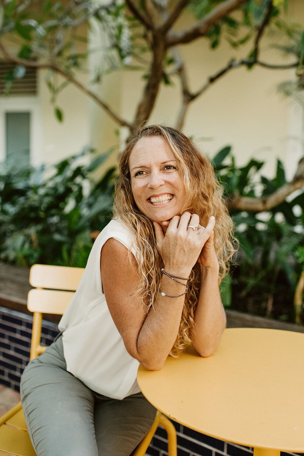 Candid lifestyle photography session at an outdoor cafe with yellow table.