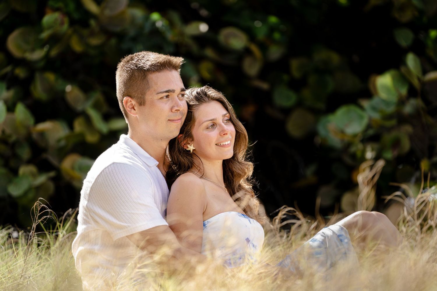Intimate outdoor portrait session in golden sunlight with natural greenery background.