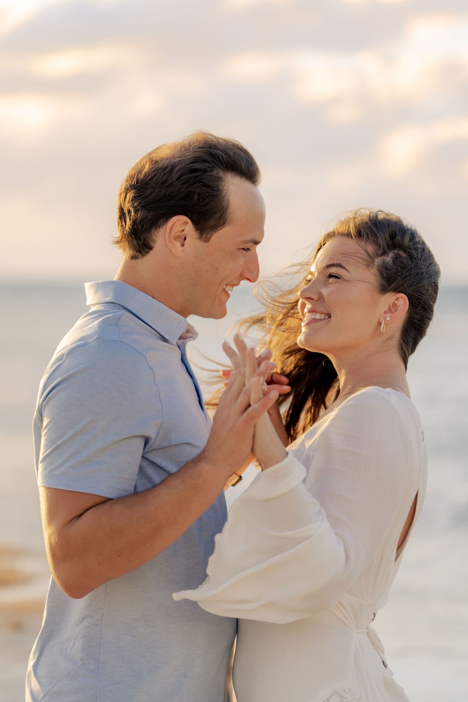 Intimate moment shared between couple during golden hour beach photoshoot.