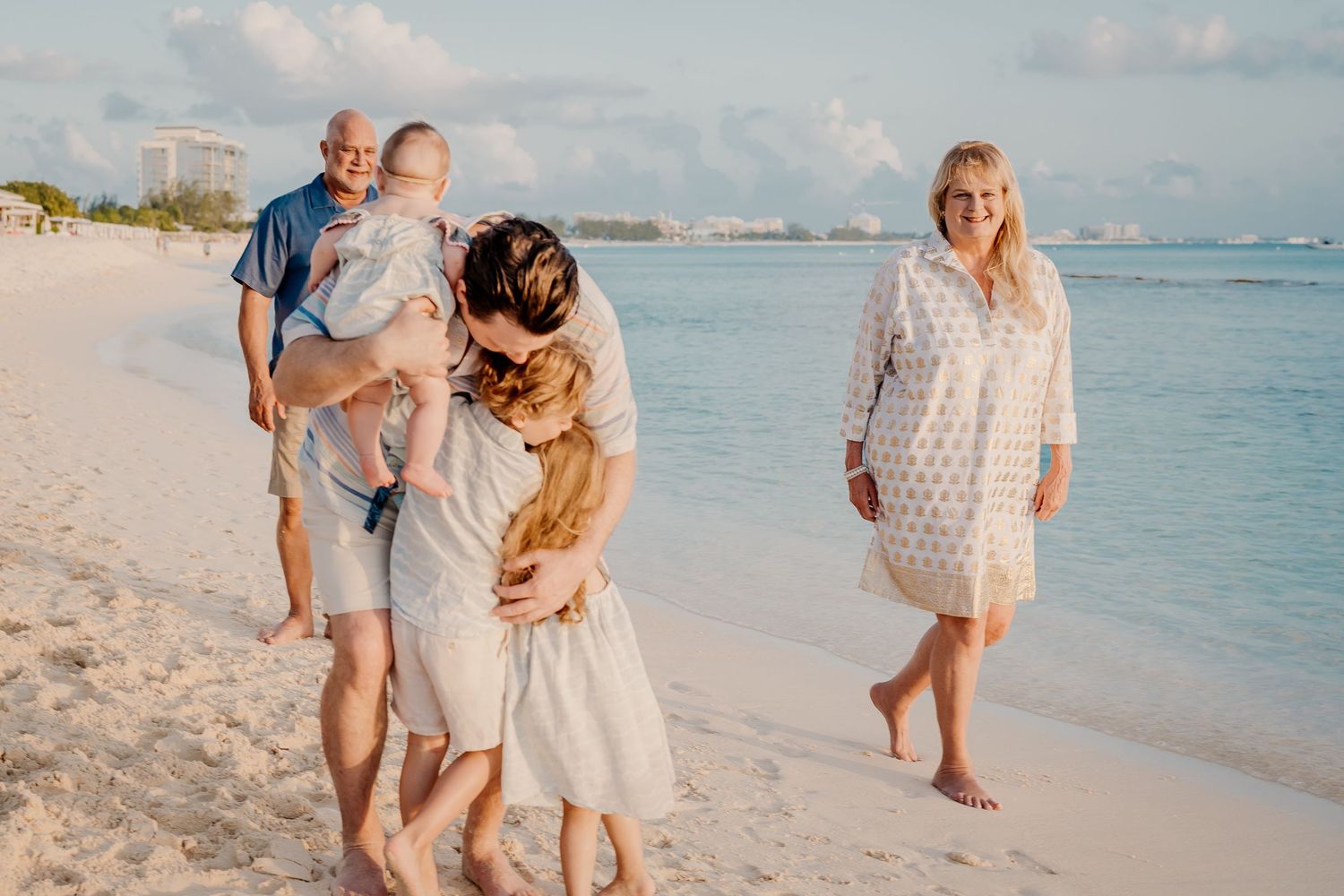 Sweet family moments captured during a beach photoshoot with soft natural lighting.