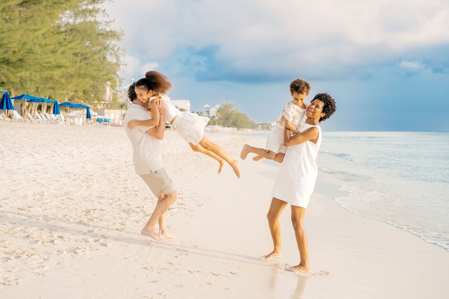 People run and play together along a beautiful tropical beach with turquoise water.