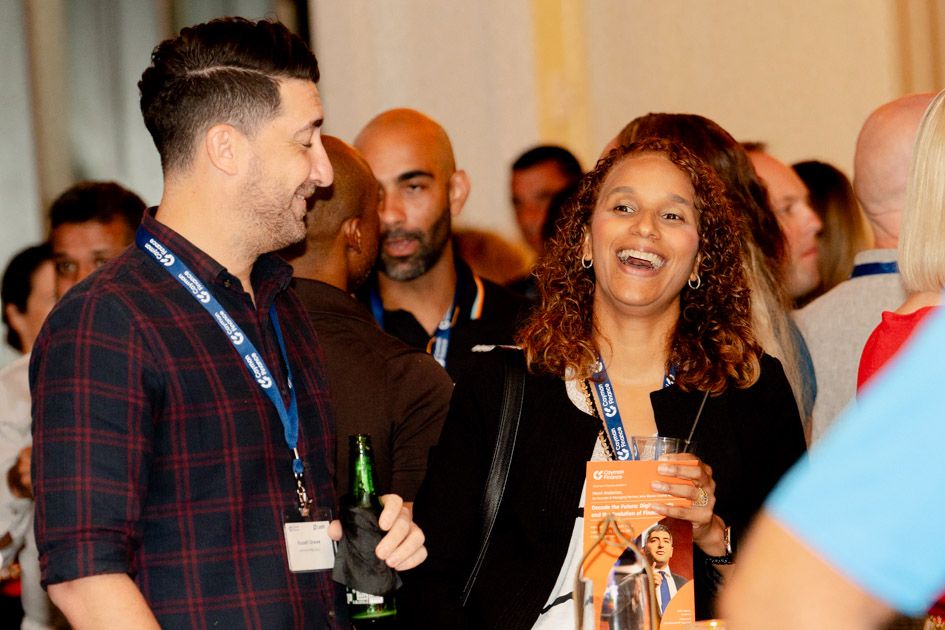Diverse group of people engaged in conversation at a business gathering.