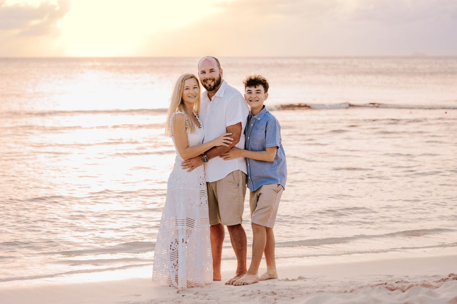 Candid beach portraits at sunset with soft golden lighting and ocean backdrop.