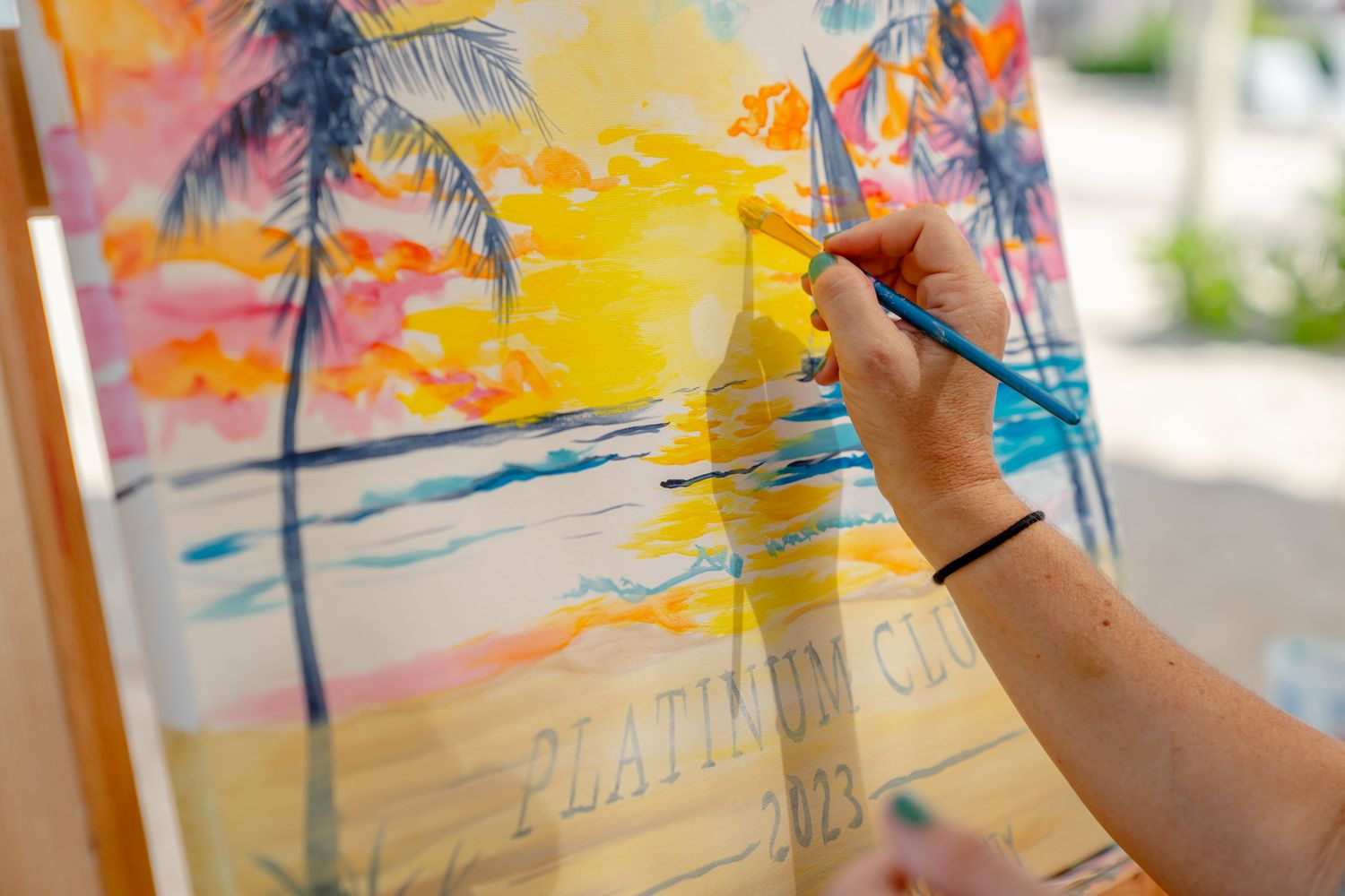 Colorful sunset beach painting with palm trees in vibrant orange and yellow hues.