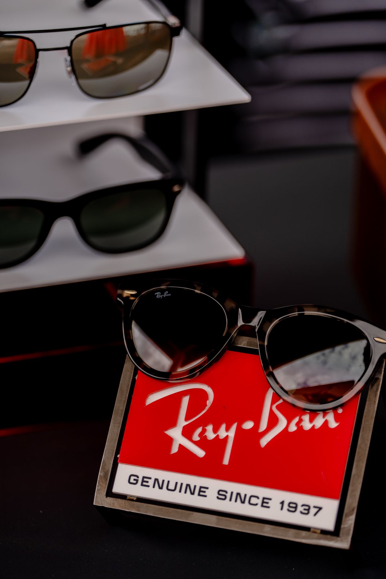 Ray-Ban branded display stands with sunglasses showcasing the genuine since 1937 logo.