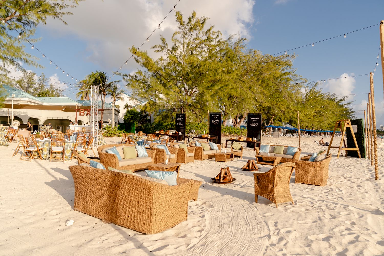 Beige lounge chairs and umbrellas line a pristine white sandy beach.