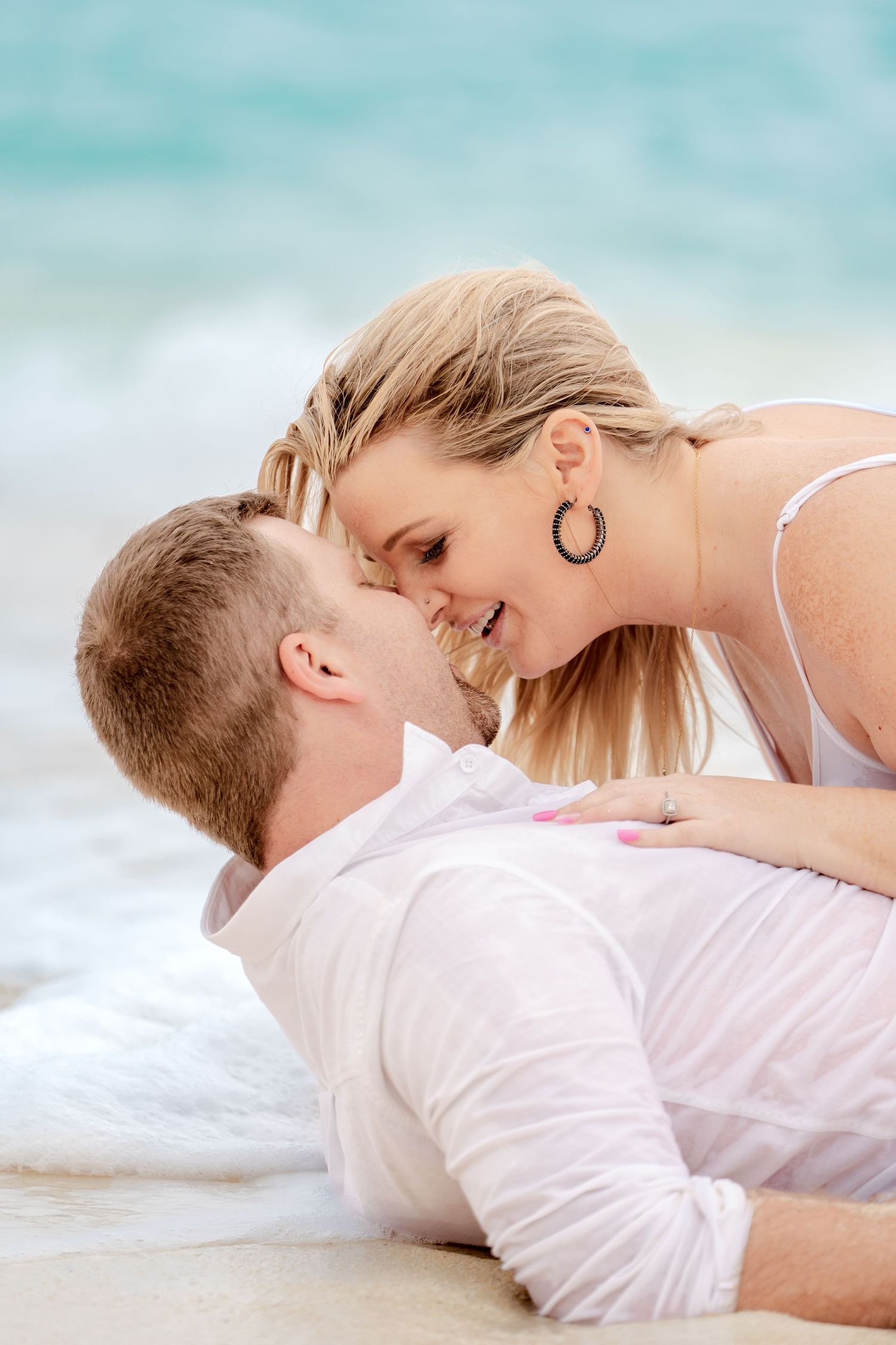 An intimate beach photoshoot with turquoise waters in the background.