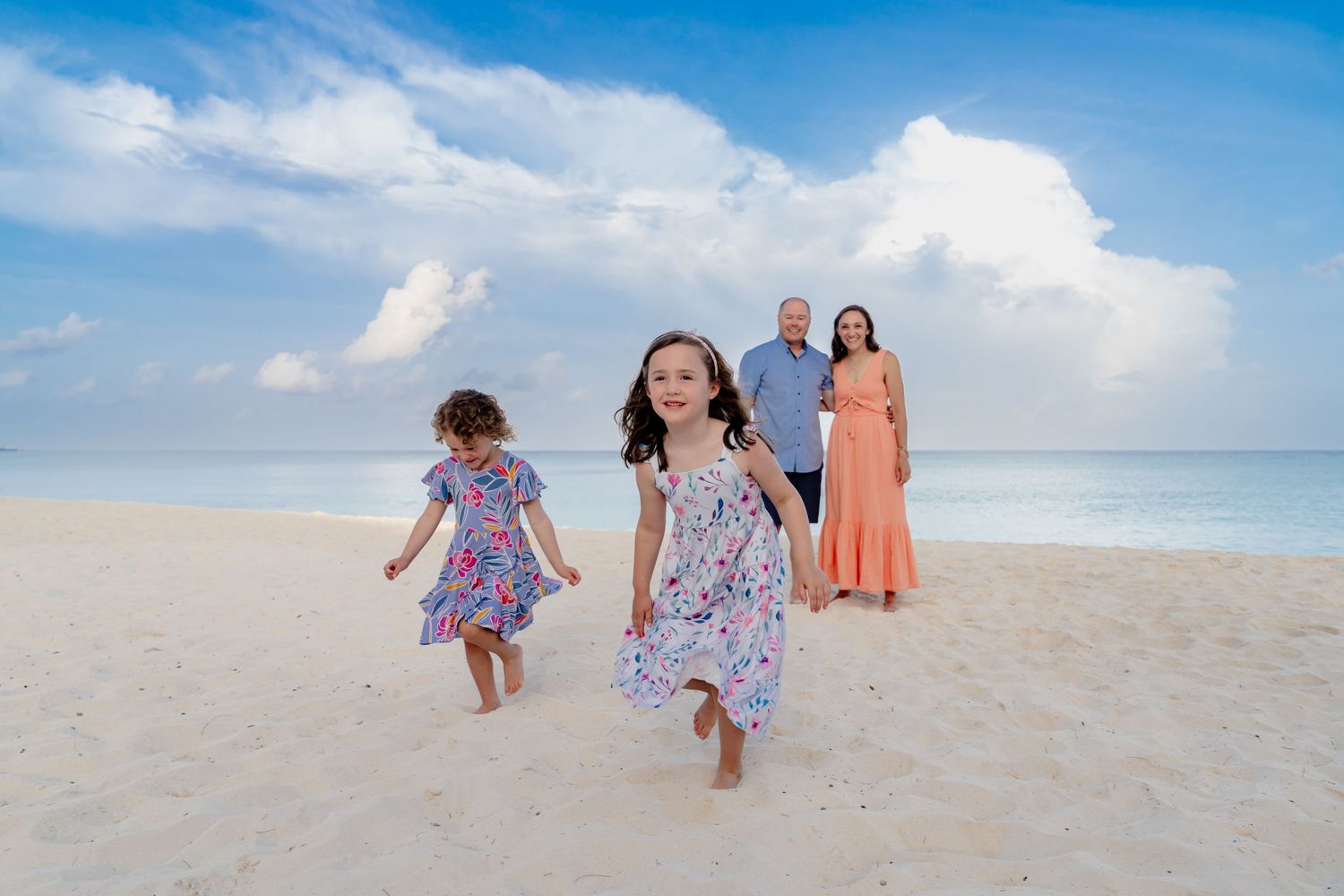 People walking and playing together on a pristine beach with bright blue skies.