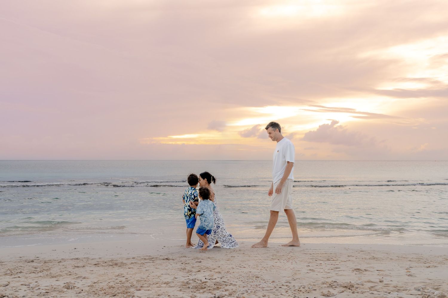 Beachgoers playing and exploring along the shoreline at dusk.