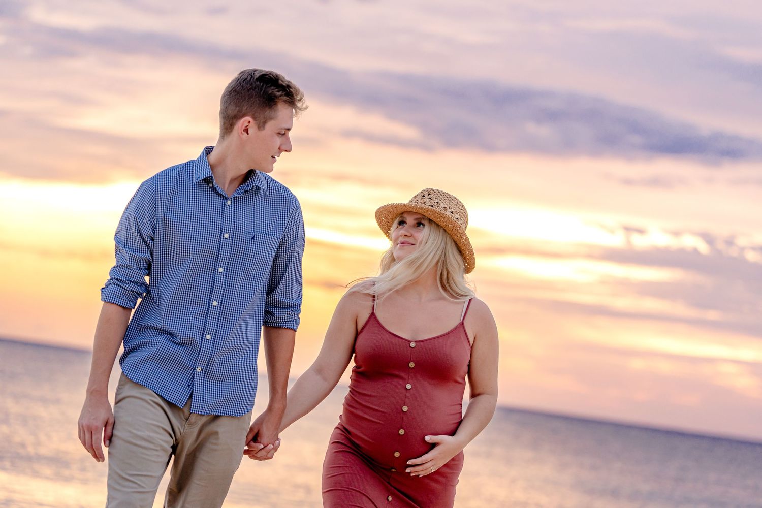 Romantic beach sunset silhouettes with warm orange sky.