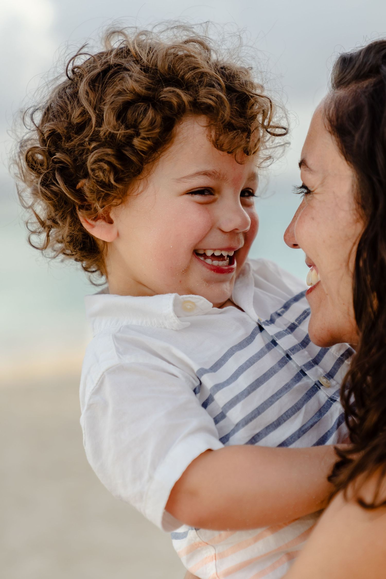 A joyful moment shared between parent and child on a sunny beach.