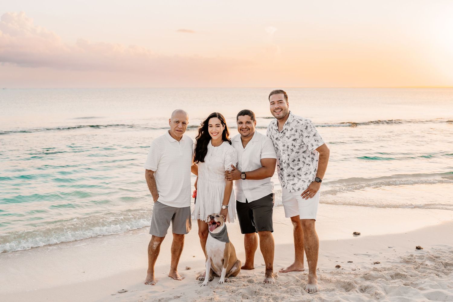 Joyful gathering on a tropical beach with white sand and turquoise waters during sunset.