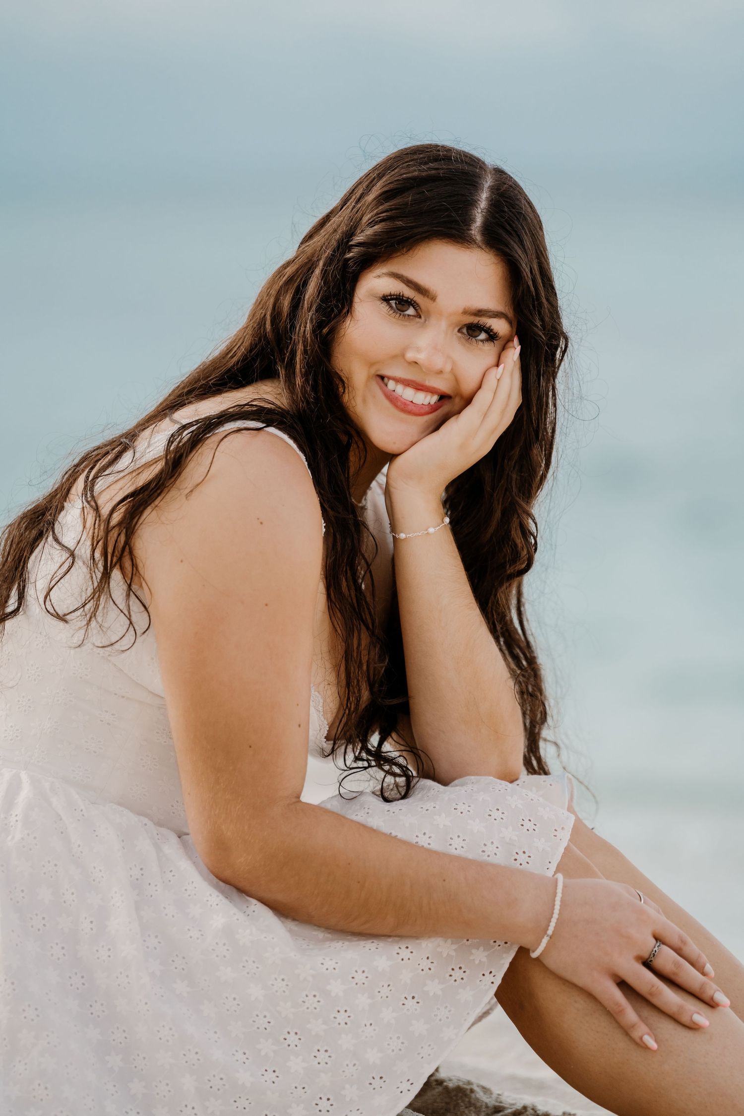 Beachside portrait series showing joyful expressions in white sundress against ocean view.