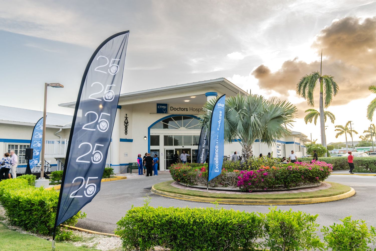 Exterior view of business center with palm trees and 25th anniversary banners.