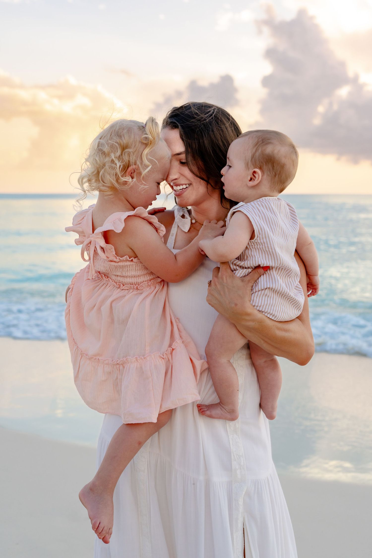 Loving family embraces on a tropical beach at sunset.