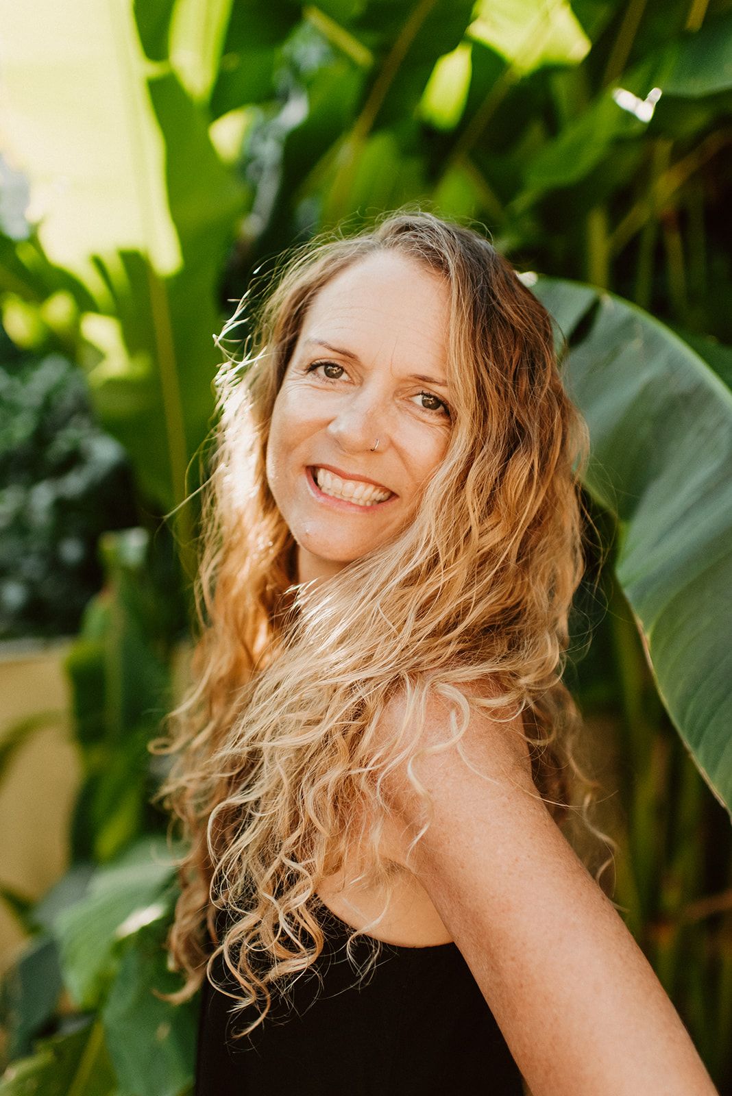 Portrait against lush tropical foliage in natural lighting.