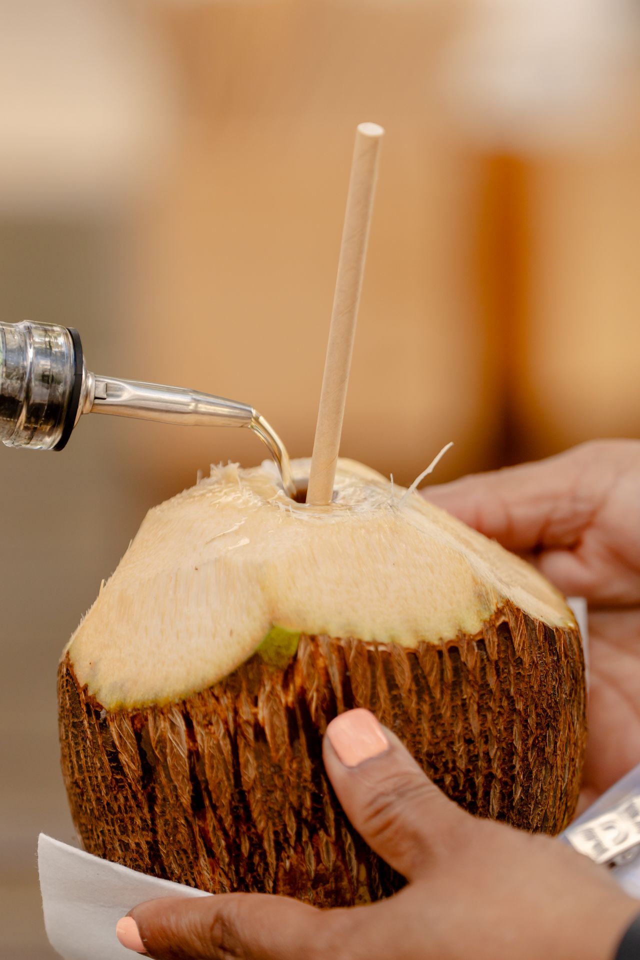 Fresh coconut drink being served with straws in natural coconut shell.