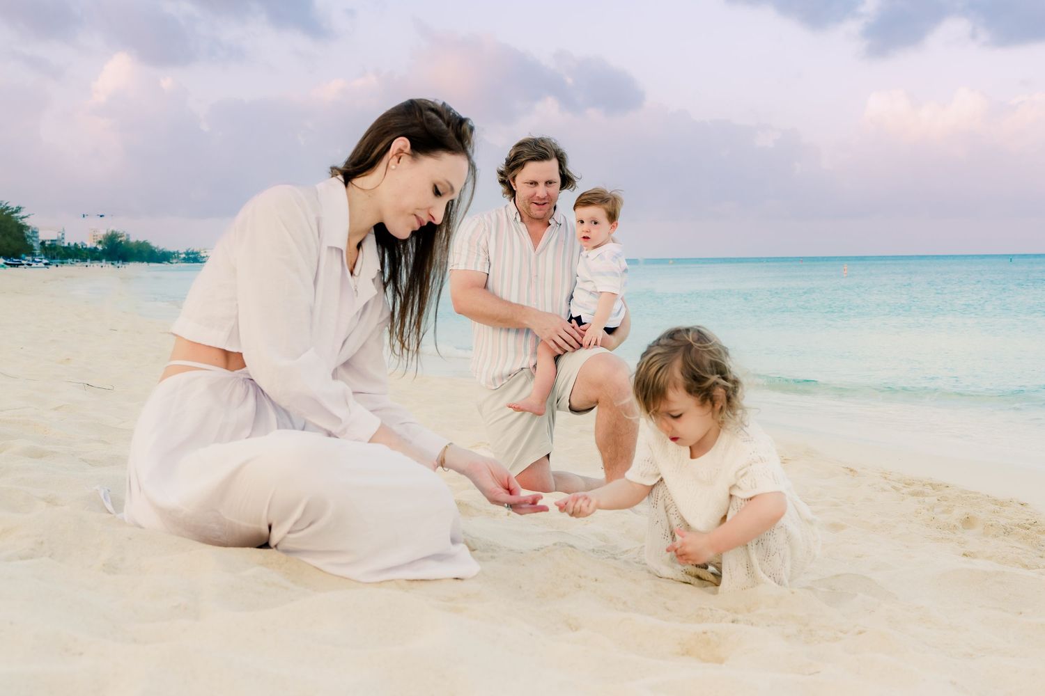 Casual family beach portraits showing natural interactions against turquoise waters.