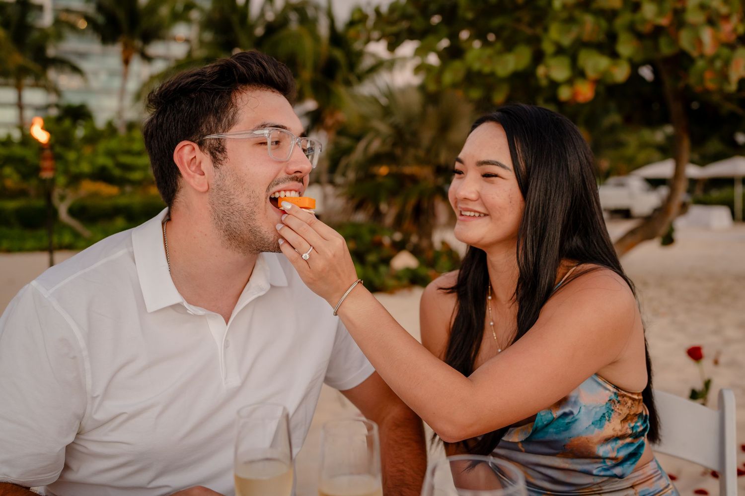 Couple sharing playful moments during sunset beach photography session.