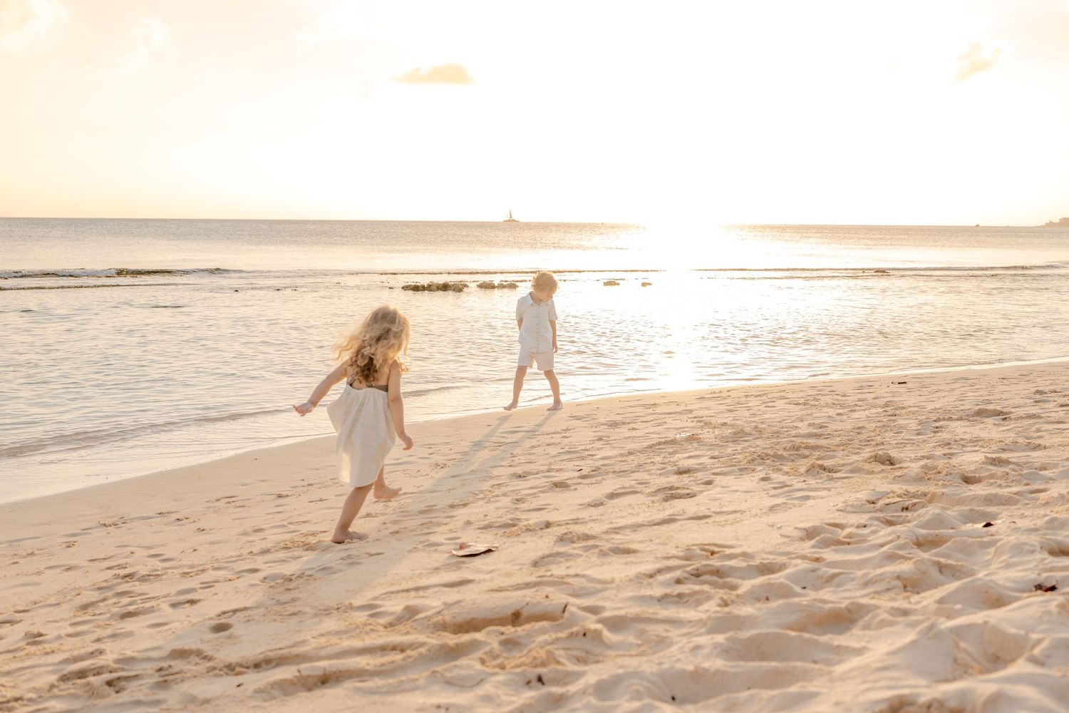Silhouettes against a dramatic beach sunset with people walking along the shoreline.