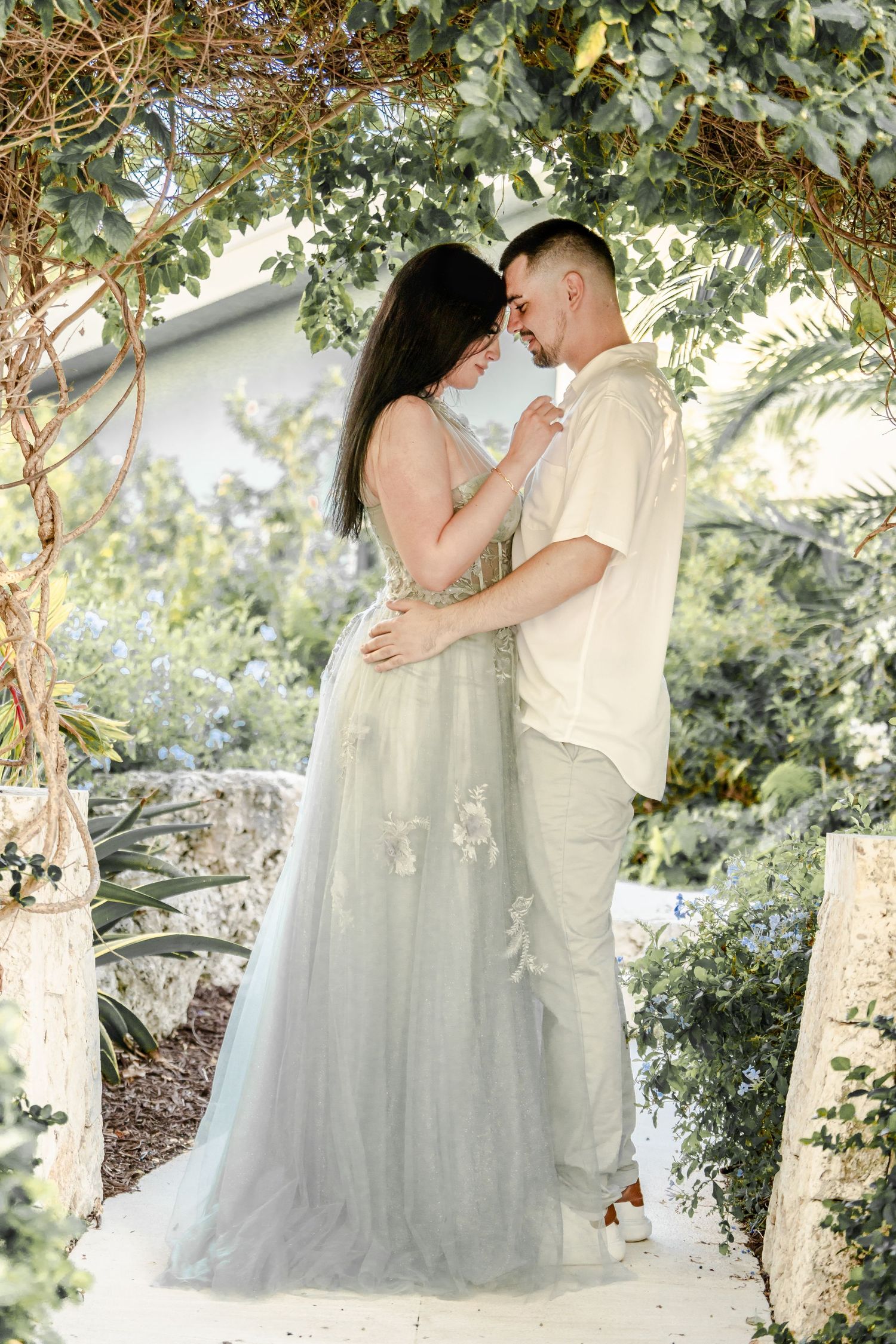 Romantic couple sharing tender moments under tree branches.