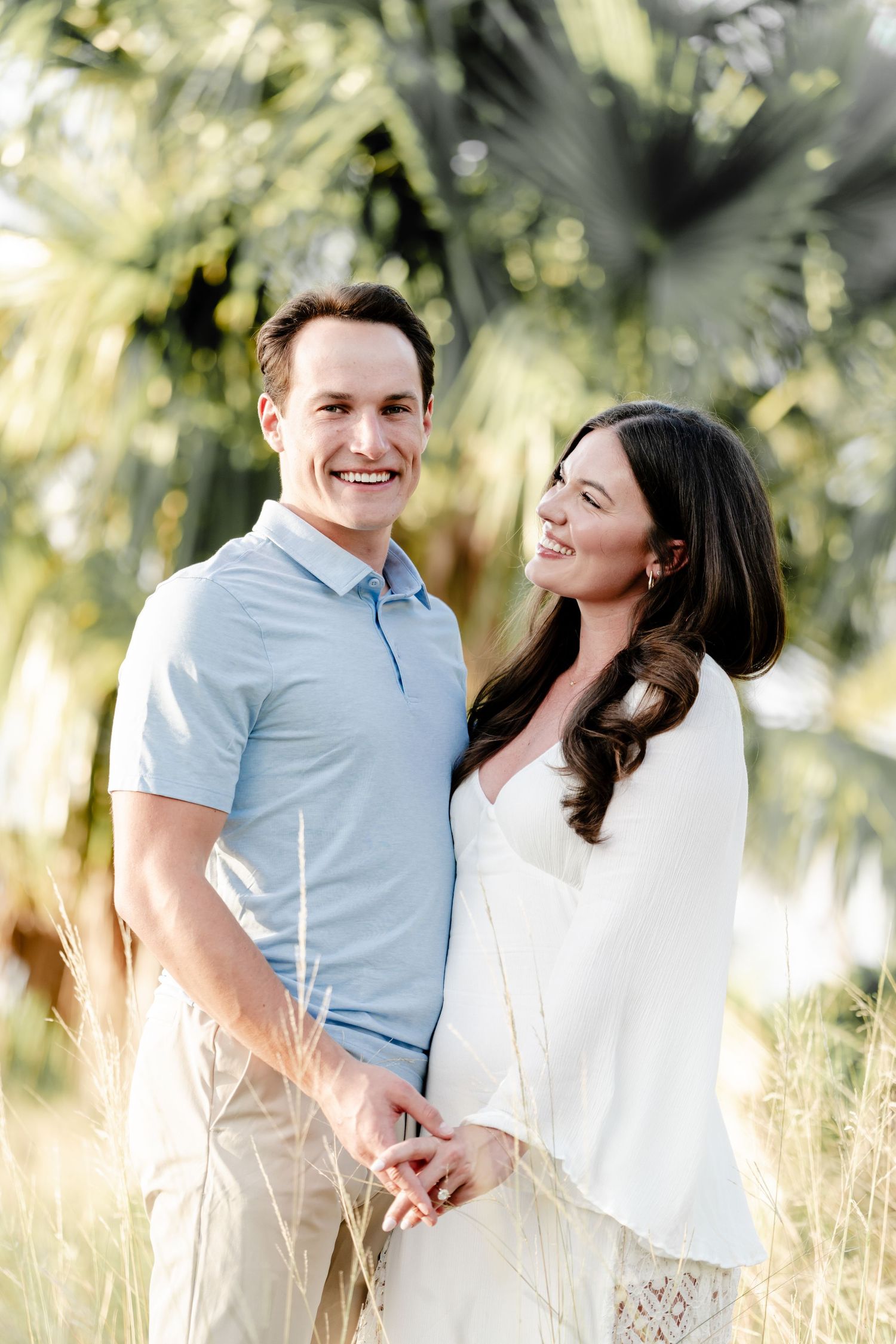Couple shares joyful moment together in tropical palm tree setting.