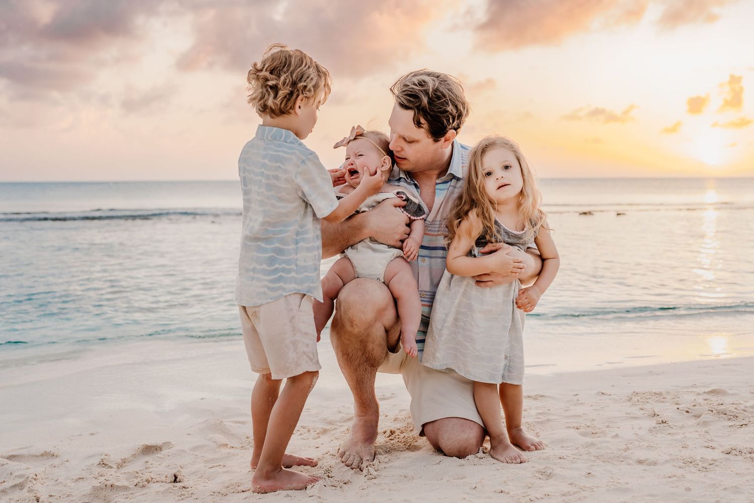 Family beach photography session during golden hour with sunset ocean backdrop.