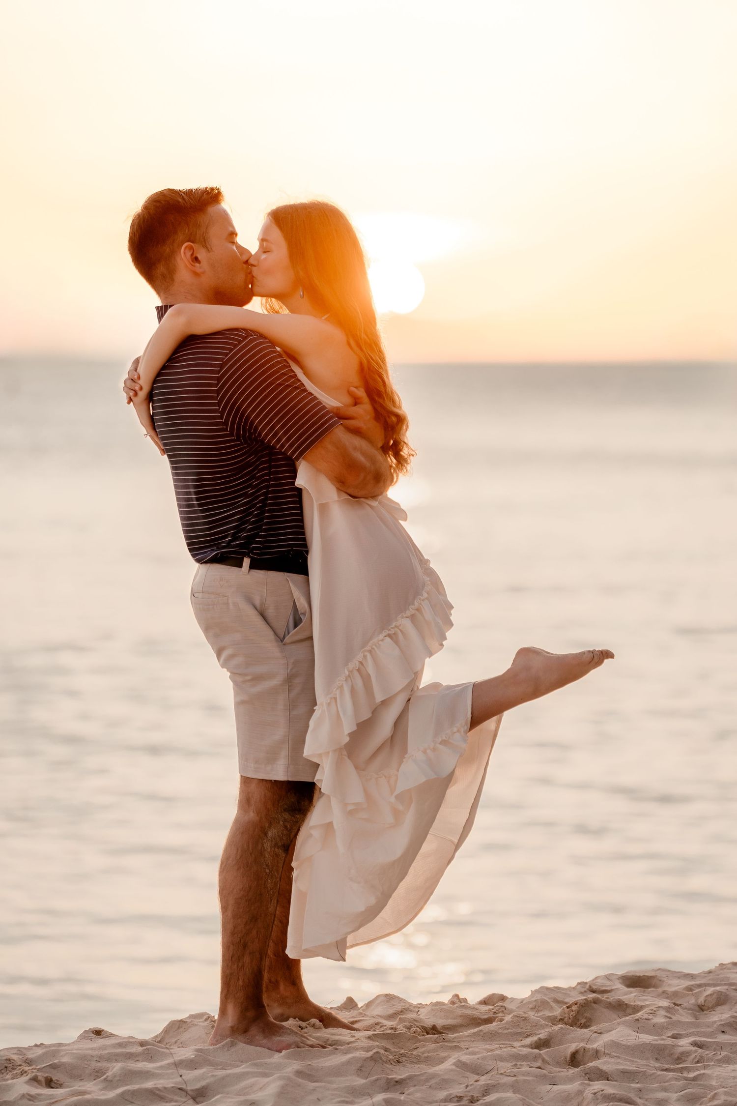 Romantic beach moment with couple embracing during golden hour.